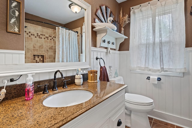 503 E Cedar Ln, Monticello, IL 61856 - bathroom with a wainscoted wall, toilet, vanity, tile patterned flooring, and a decorative wall