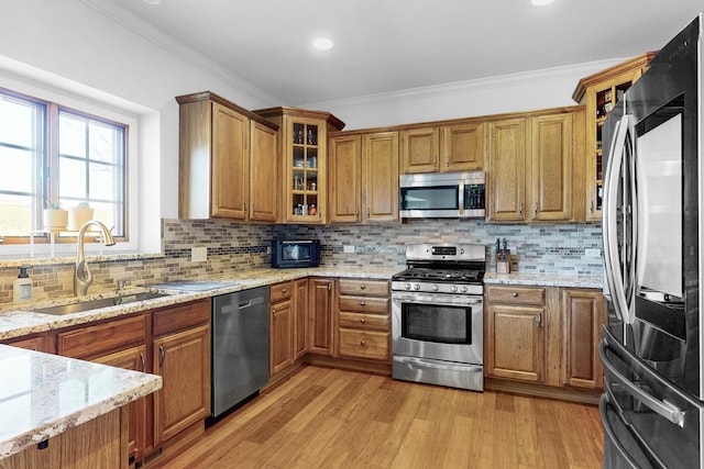 118 Jack Dylan Dr, Hampshire, IL 60140 - kitchen with brown cabinetry, crown molding, a sink, light wood finished floors, and appliances with stainless steel finishes