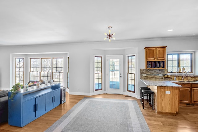 118 Jack Dylan Dr, Hampshire, IL 60140 - kitchen with light wood-type flooring, a sink, baseboards, and a kitchen bar