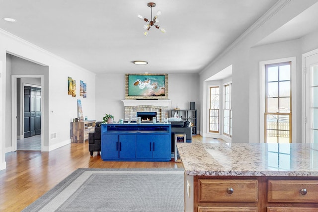 118 Jack Dylan Dr, Hampshire, IL 60140 - living area with a notable chandelier, a fireplace, baseboards, light wood-type flooring, and ornamental molding