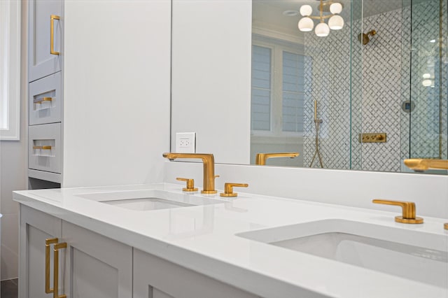 full bath with a sink, a stall shower, and double vanity