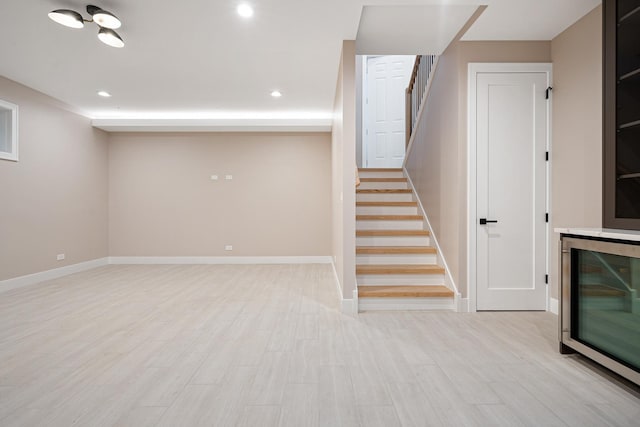 basement featuring stairs, recessed lighting, baseboards, and wood finished floors