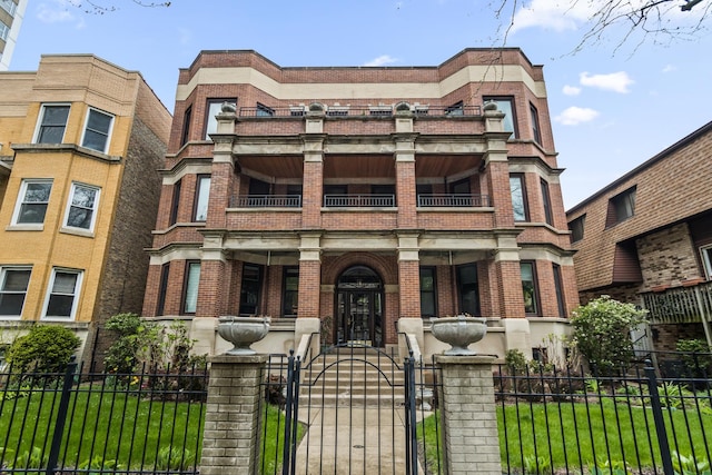 900 W Lakeside Pl Unit 2, Chicago, IL 60640 - view of front of property featuring covered porch, a fenced front yard, a gate, brick siding, and a balcony