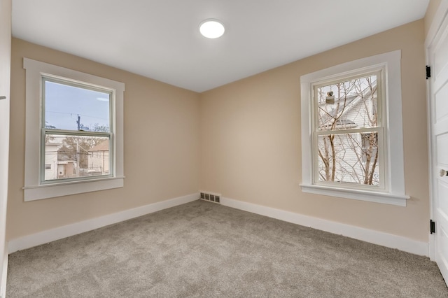 spare room with visible vents, carpet flooring, baseboards, and a healthy amount of sunlight