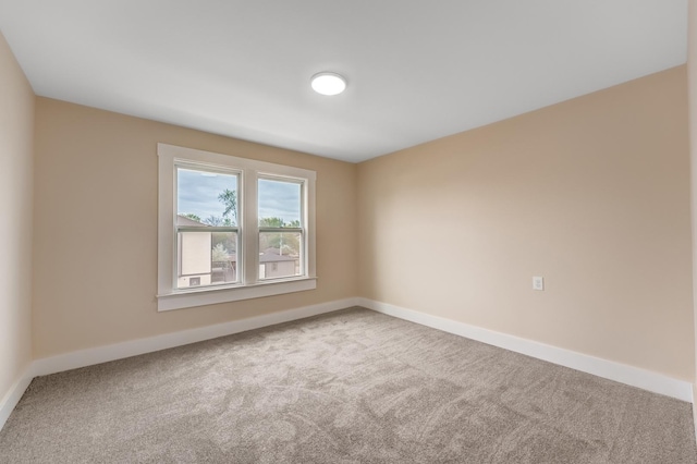 unfurnished room featuring baseboards and carpet