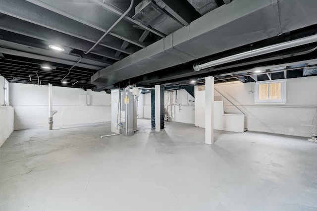 below grade area featuring water heater and stairway