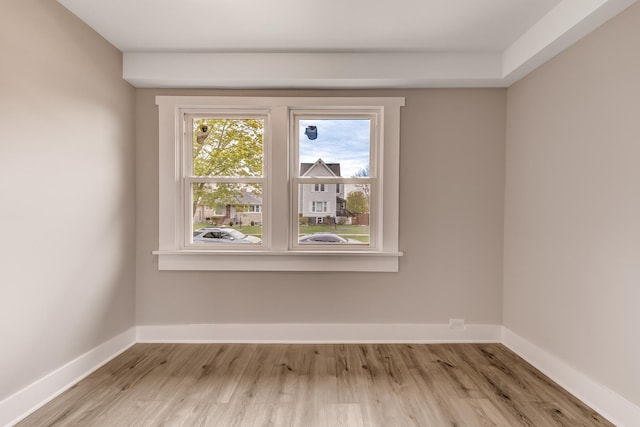 empty room with baseboards and light wood finished floors