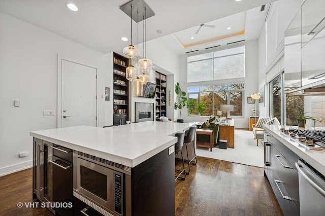 2109 N Campbell Ave Unit 2N, Chicago, IL 60647 - kitchen featuring light countertops, a breakfast bar, appliances with stainless steel finishes, baseboards, and a desk