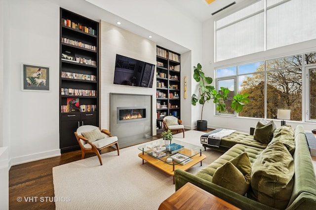 2109 N Campbell Ave Unit 2N, Chicago, IL 60647 - living area with a fireplace with flush hearth, wood finished floors, baseboards, built in shelves, and a towering ceiling
