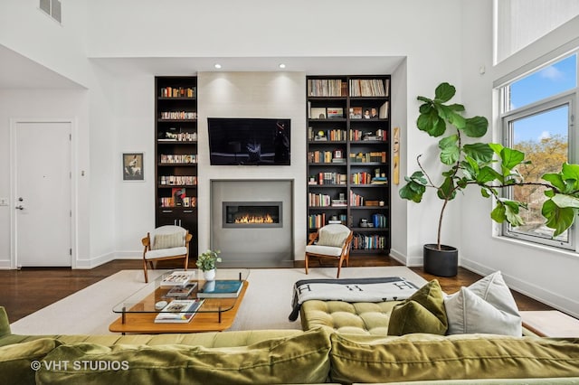 2109 N Campbell Ave Unit 2N, Chicago, IL 60647 - living area featuring a fireplace, wood finished floors, baseboards, built in shelves, and a towering ceiling