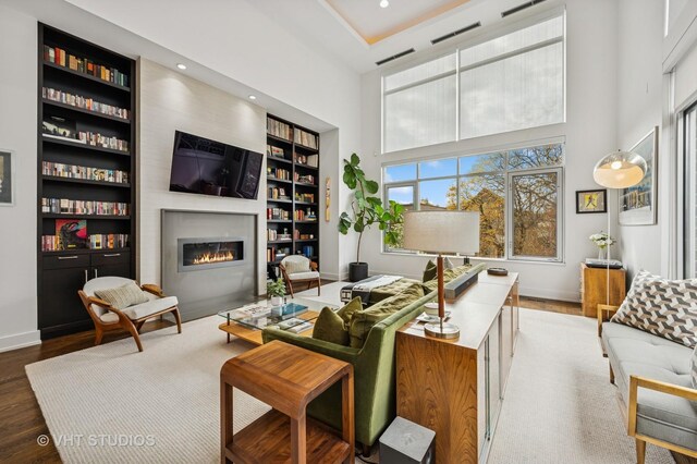 2109 N Campbell Ave Unit 2N, Chicago, IL 60647 - living area with wood finished floors, a glass covered fireplace, built in shelves, baseboards, and a high ceiling
