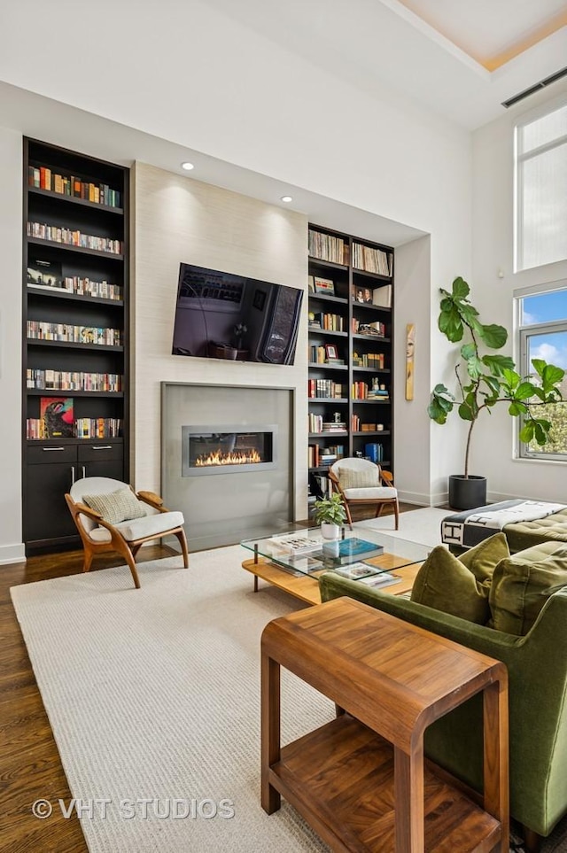 2109 N Campbell Ave Unit 2N, Chicago, IL 60647 - living room with a glass covered fireplace, built in shelves, wood finished floors, baseboards, and a high ceiling