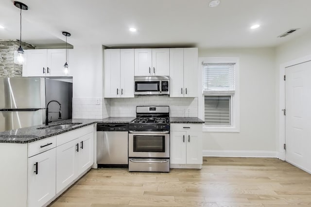 2437 W Taylor St, Chicago, IL 60612 - kitchen featuring appliances with stainless steel finishes, white cabinetry, dark stone counters, backsplash, and recessed lighting