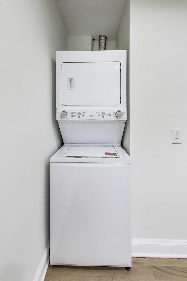 2437 W Taylor St, Chicago, IL 60612 - laundry area with stacked washing machine and dryer and wood finished floors