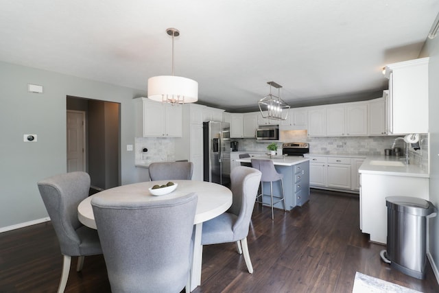 dining space with dark wood-type flooring, baseboards, and a notable chandelier
