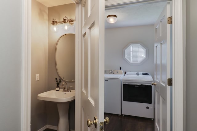 laundry room featuring a sink, laundry area, washing machine and dryer, and dark wood-style floors