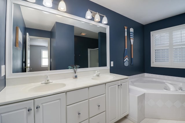 full bathroom featuring double vanity, a sink, a garden tub, and a stall shower