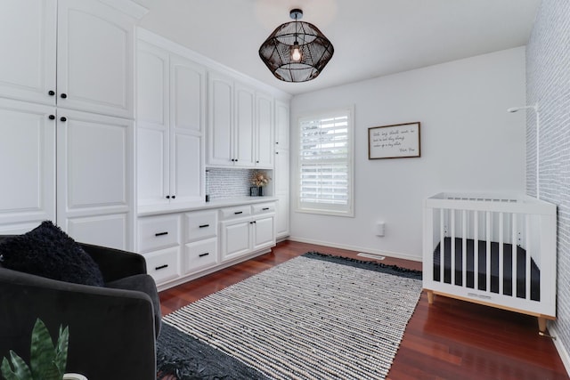 bedroom featuring baseboards and dark wood finished floors