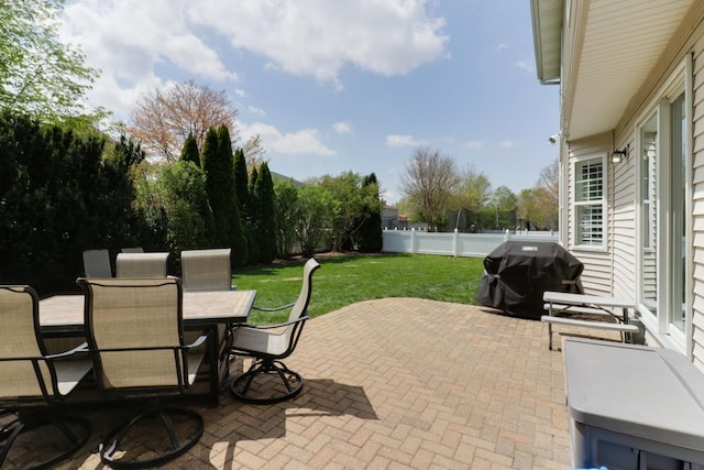 view of patio featuring a fenced backyard, a fire pit, outdoor dining area, and grilling area