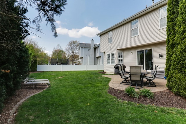rear view of property featuring fence, a yard, and a patio area