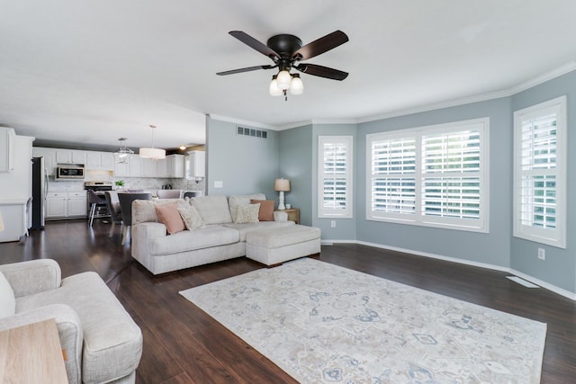 living room featuring visible vents, ornamental molding, dark wood finished floors, and ceiling fan