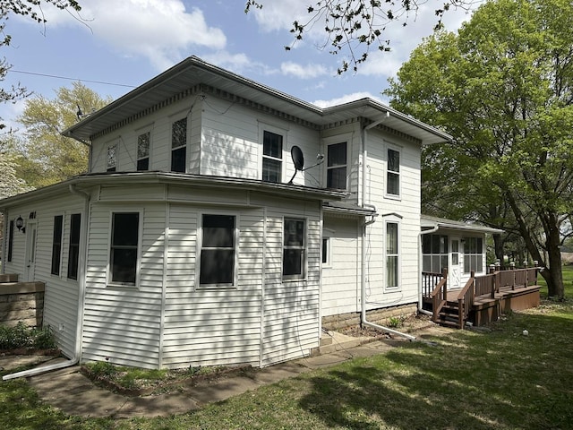 rear view of house with a yard and a wooden deck