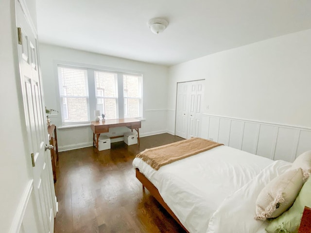 bedroom featuring a closet, dark wood-style flooring, and baseboards
