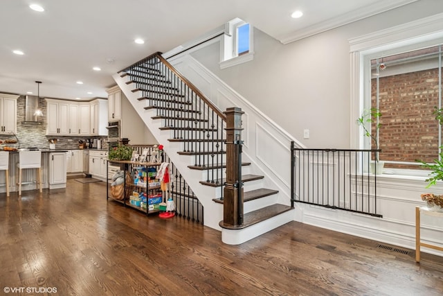 stairs featuring a wainscoted wall, a decorative wall, recessed lighting, and wood finished floors