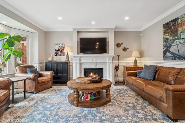 living room with crown molding, a wainscoted wall, recessed lighting, wood finished floors, and a high end fireplace