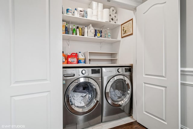 laundry area with laundry area, wood finished floors, and washing machine and clothes dryer