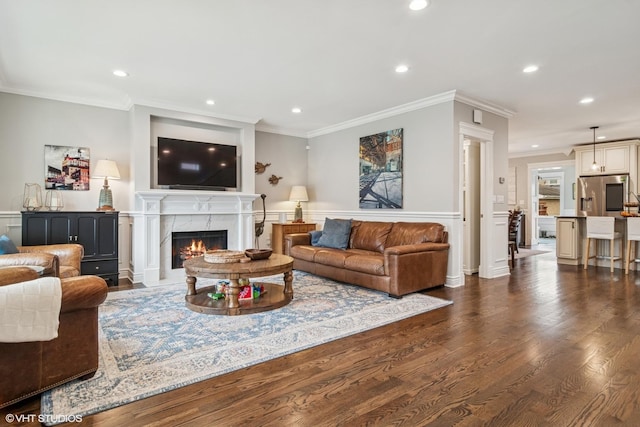 living room with crown molding, recessed lighting, dark wood-style floors, and a high end fireplace