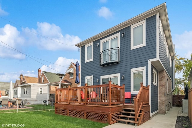 back of property featuring a fenced backyard, a wooden deck, and a yard