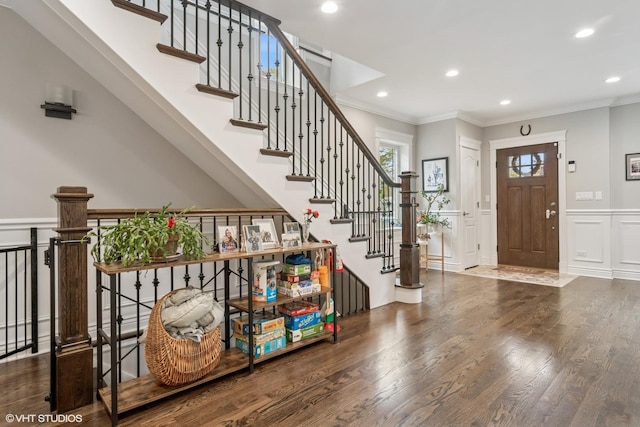 entryway with ornamental molding, wainscoting, wood finished floors, a decorative wall, and recessed lighting
