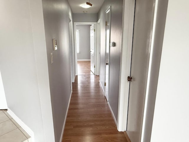 hall featuring baseboards and wood finished floors