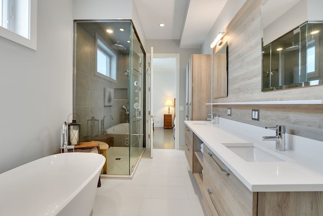 full bathroom featuring a sink, double vanity, recessed lighting, a freestanding tub, and a stall shower