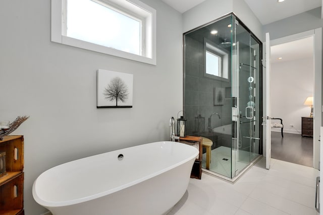 full bathroom featuring tile patterned floors, recessed lighting, baseboards, a shower stall, and a soaking tub