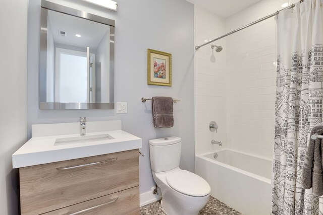 bathroom featuring vanity, toilet, baseboards, and shower / tub combo