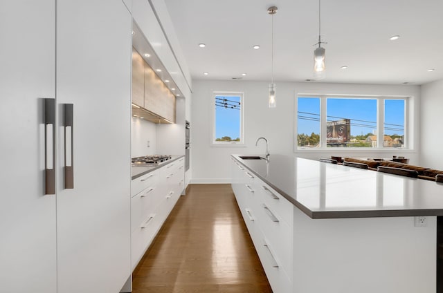 kitchen with stainless steel gas cooktop, modern cabinets, white cabinets, a large island with sink, and a sink