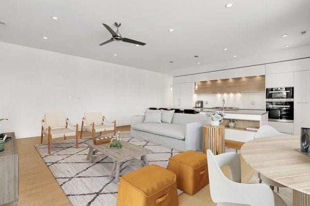 living area featuring recessed lighting, a ceiling fan, and light wood-style floors