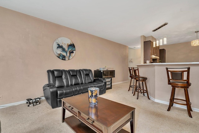 living area with baseboards and light carpet