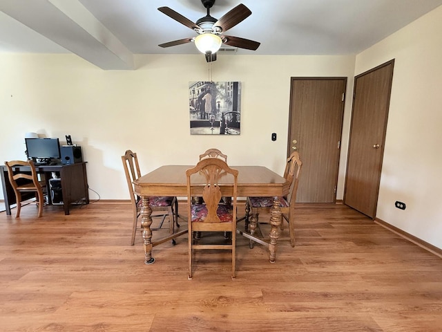 dining space featuring a ceiling fan, light wood finished floors, and baseboards