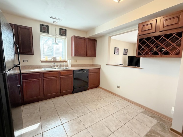 kitchen with black appliances, a sink, light countertops, light tile patterned floors, and hanging light fixtures
