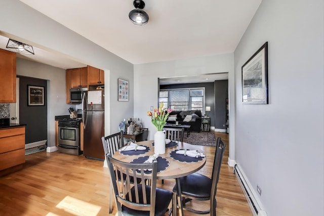 4855 Dobson St Unit 304, Skokie, IL 60077 - dining area featuring baseboards, light wood finished floors, and a baseboard heating unit