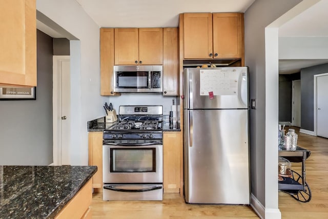4855 Dobson St Unit 304, Skokie, IL 60077 - kitchen with light wood-style flooring, dark stone countertops, and stainless steel appliances