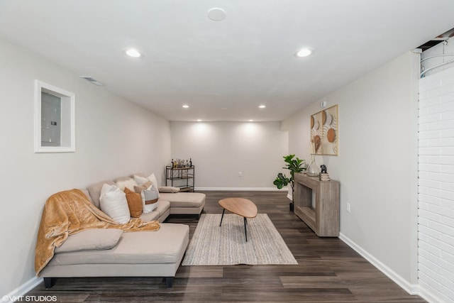 living area with electric panel, visible vents, dark wood finished floors, baseboards, and recessed lighting