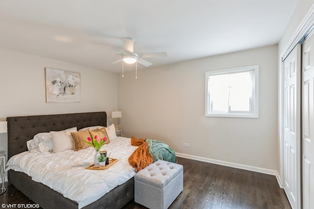 bedroom with a ceiling fan, baseboards, dark wood finished floors, and a closet