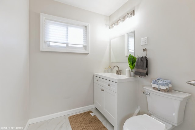 half bathroom with vanity, baseboards, toilet, and marble finish floor