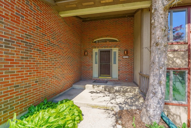 doorway to property with brick siding