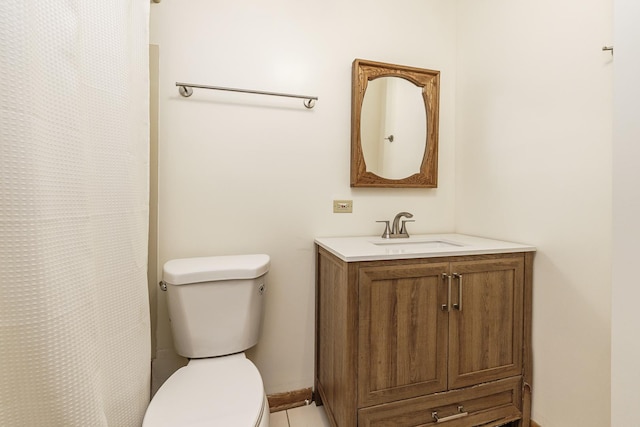bathroom with toilet, vanity, and tile patterned floors