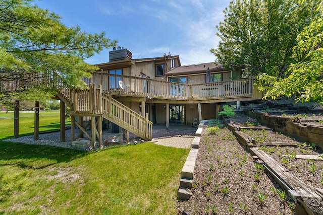 back of house featuring a wooden deck, a lawn, stairway, and a chimney